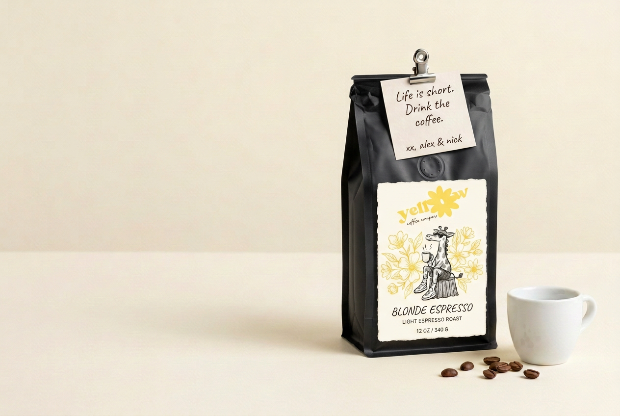 Black coffee bag with Yellow's floral giraffe label and a handwritten note from Alex and Nick beside a coffee cup